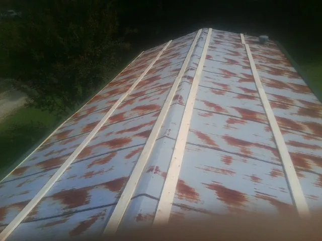 Rusted metal roof panels with new wood purlins before replacement — Storm Damage Roof Repair in Blandford by Roofing Brothers